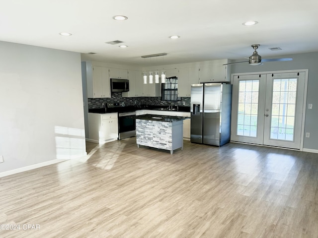 kitchen with gray cabinetry, french doors, stainless steel appliances, light hardwood / wood-style floors, and a kitchen island