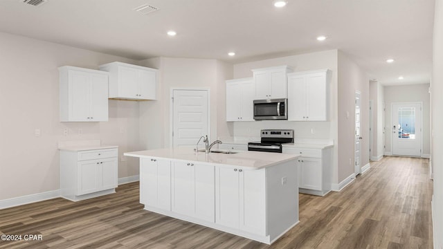 kitchen featuring stainless steel appliances, white cabinetry, a kitchen island with sink, and sink