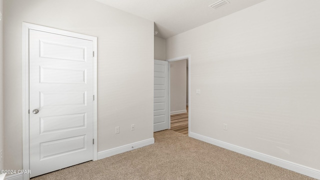 unfurnished bedroom featuring light carpet