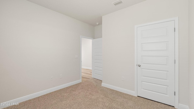 unfurnished bedroom featuring light carpet