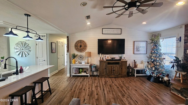 living room featuring dark hardwood / wood-style floors, ceiling fan, lofted ceiling, and wood walls