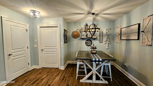 unfurnished dining area with a textured ceiling, dark hardwood / wood-style floors, and a notable chandelier