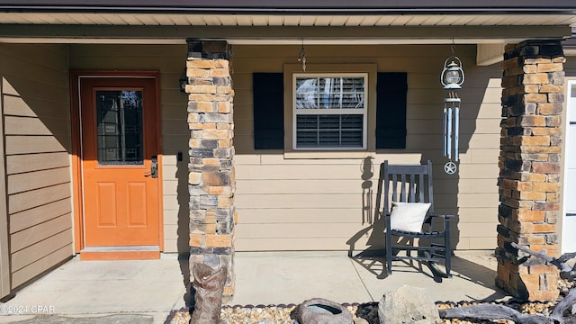 view of exterior entry featuring covered porch