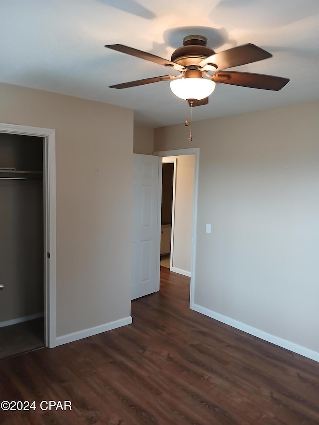 unfurnished bedroom featuring ceiling fan, dark hardwood / wood-style floors, and a closet