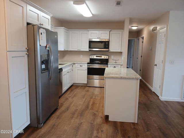 kitchen with white cabinetry, light stone countertops, dark hardwood / wood-style floors, a kitchen island, and appliances with stainless steel finishes