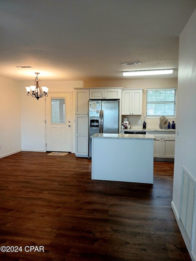 kitchen with white cabinets, decorative light fixtures, an inviting chandelier, and dark hardwood / wood-style floors