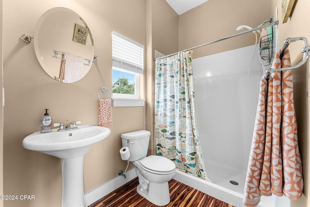 bathroom featuring hardwood / wood-style flooring, sink, toilet, and walk in shower