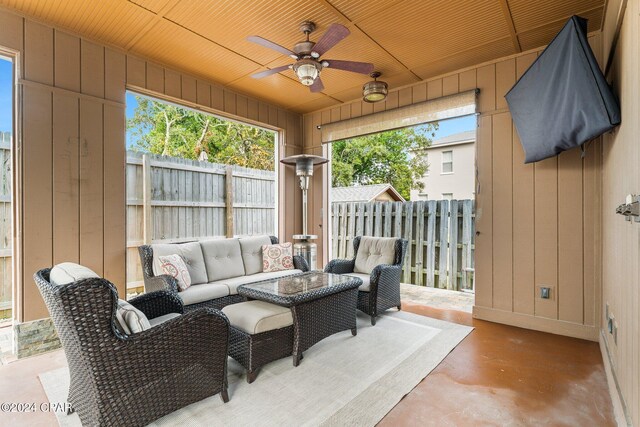 sunroom featuring ceiling fan and wood ceiling