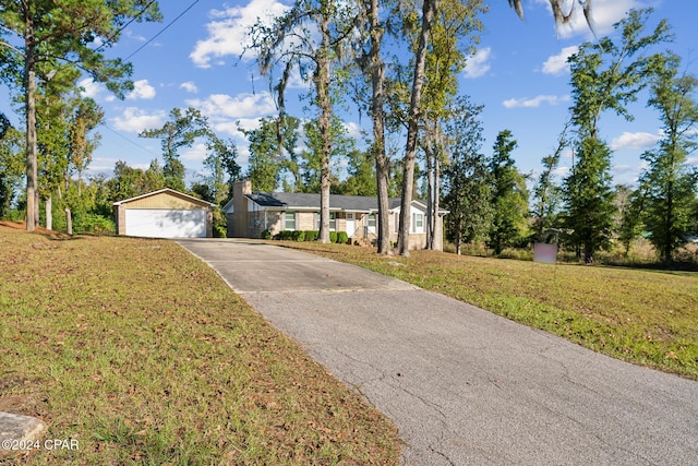 ranch-style house featuring a garage, an outdoor structure, and a front lawn