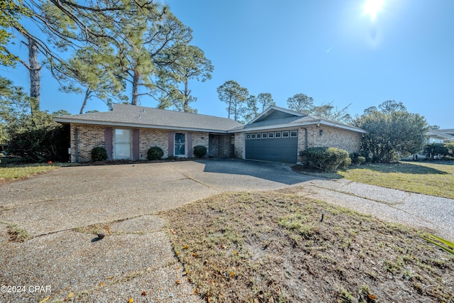 single story home featuring a front lawn and a garage