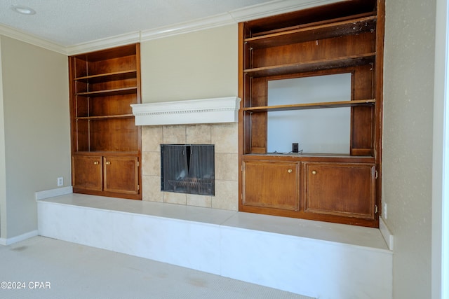 unfurnished living room featuring built in features, crown molding, light carpet, and a tiled fireplace