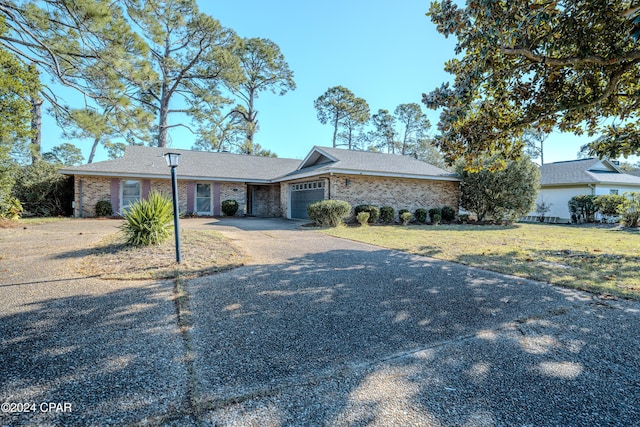 ranch-style home with a garage and a front lawn