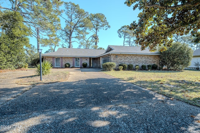 ranch-style home with a garage and a front lawn