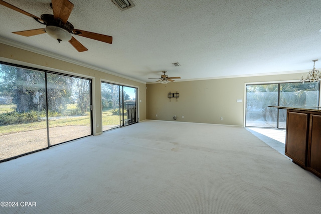 interior space with a textured ceiling, light colored carpet, and crown molding