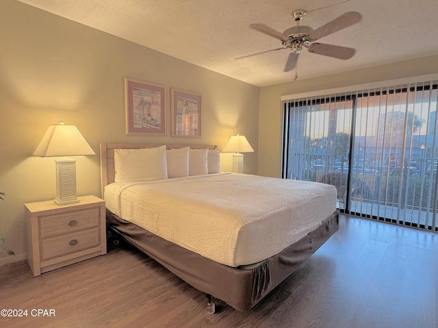 bedroom featuring hardwood / wood-style floors, a textured ceiling, access to outside, and ceiling fan