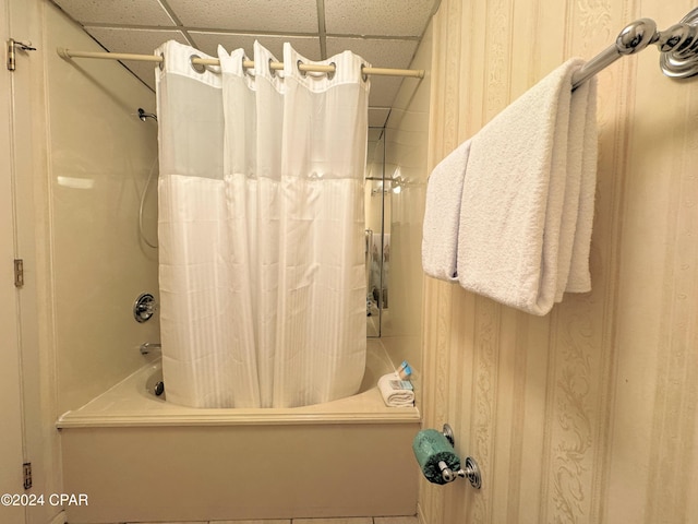 bathroom featuring shower / tub combo with curtain and a drop ceiling