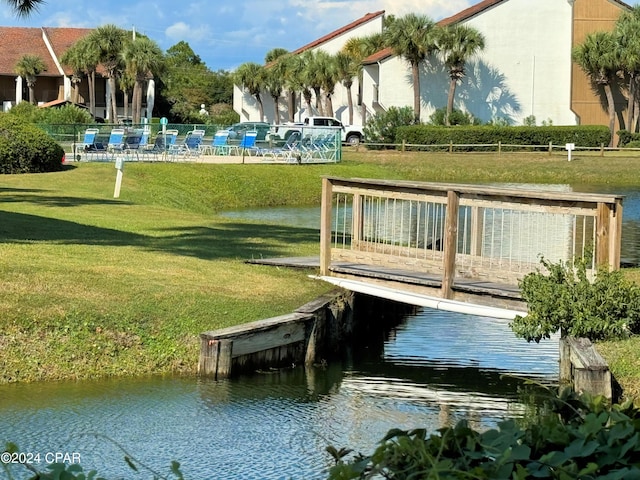 dock area featuring a water view and a lawn