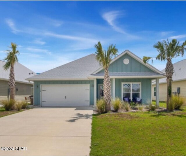 ranch-style home featuring a garage and a front lawn