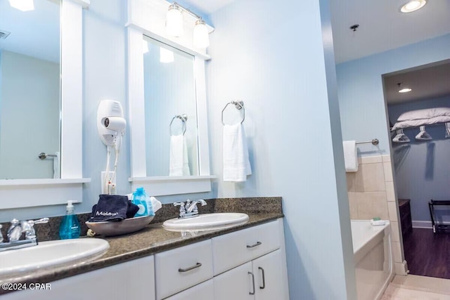 bathroom featuring hardwood / wood-style floors, vanity, and a tub