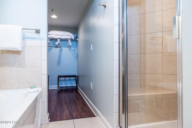 bathroom featuring hardwood / wood-style floors and plus walk in shower