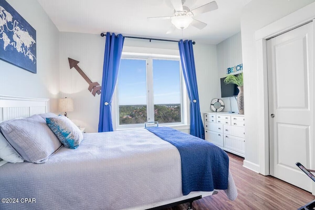 bedroom featuring hardwood / wood-style flooring, ceiling fan, and a closet