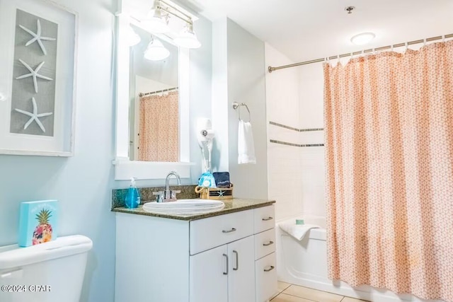 full bathroom with tile patterned flooring, shower / bath combination with curtain, vanity, and toilet