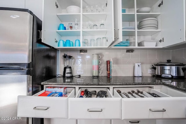 kitchen featuring white cabinets, stainless steel refrigerator, and tasteful backsplash