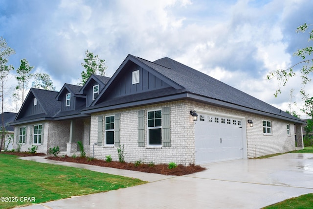 view of home's exterior with driveway, a yard, brick siding, a garage, and board and batten siding