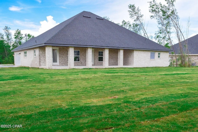 rear view of property with brick siding and a lawn