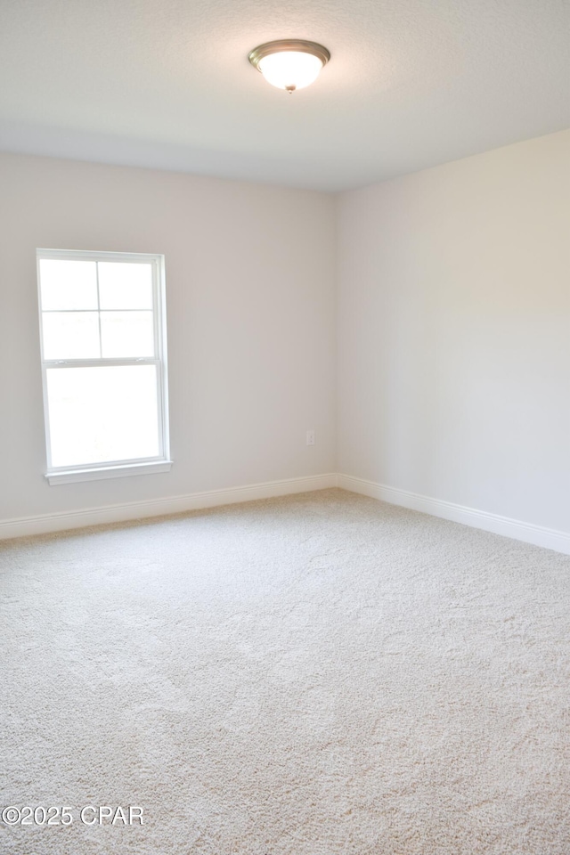 carpeted empty room with baseboards