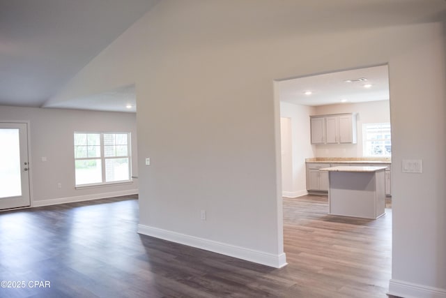 interior space with dark wood finished floors, recessed lighting, baseboards, and vaulted ceiling