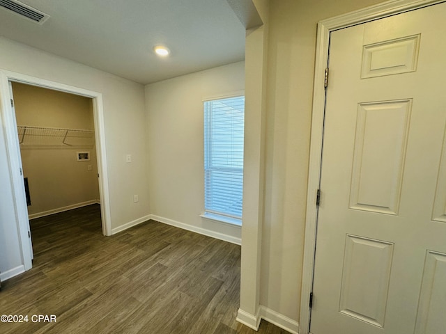 unfurnished bedroom with dark hardwood / wood-style floors, a spacious closet, and a closet