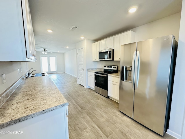 kitchen featuring stainless steel appliances, white cabinetry, ceiling fan, and sink