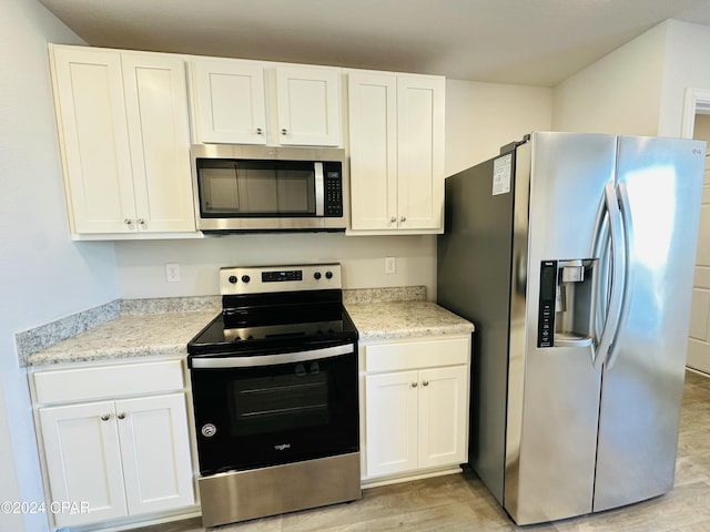 kitchen featuring white cabinets, light hardwood / wood-style floors, and appliances with stainless steel finishes