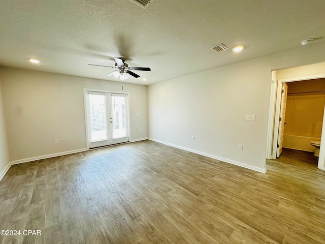 unfurnished room featuring french doors, a textured ceiling, light hardwood / wood-style floors, and ceiling fan