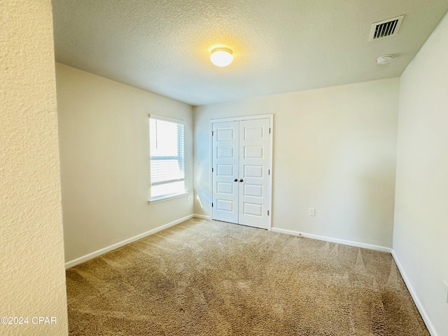 spare room with carpet floors and a textured ceiling