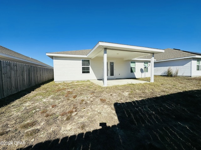 back of property with a patio area and a yard