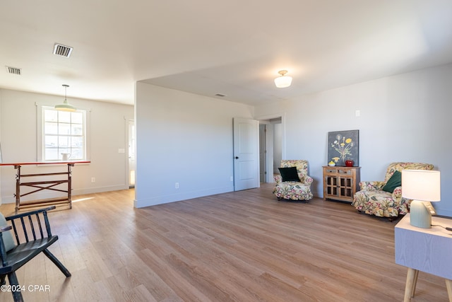 living area with light wood finished floors, baseboards, and visible vents