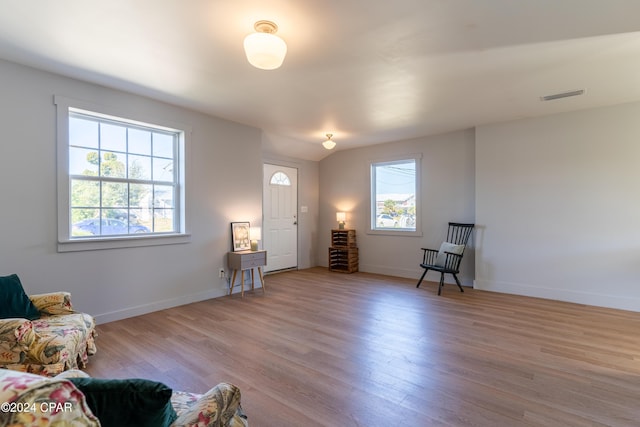 living area featuring light wood-style floors, baseboards, and visible vents