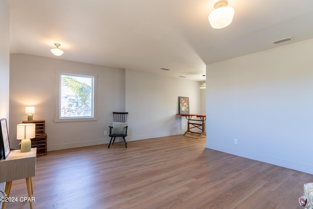 sitting room with light wood finished floors, baseboards, and visible vents