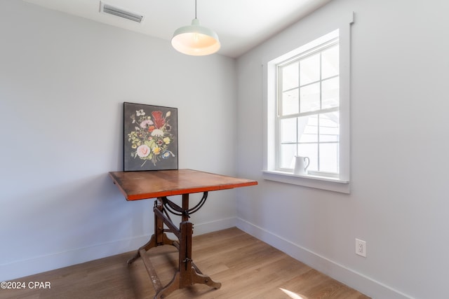 dining space featuring wood finished floors, visible vents, and baseboards