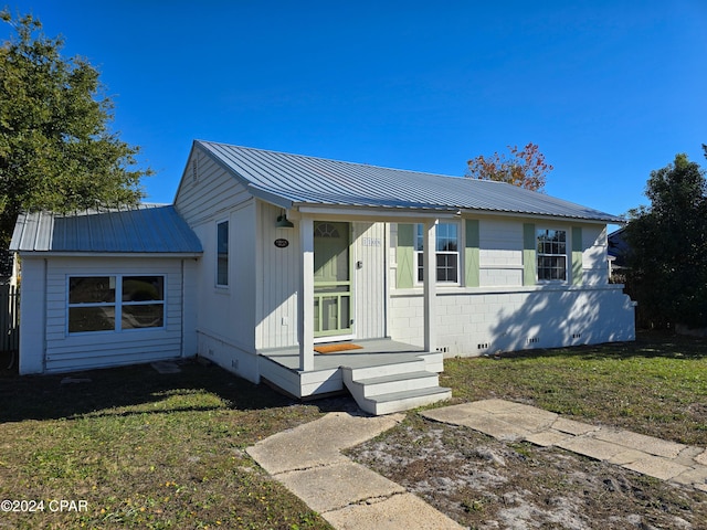 view of front of home featuring a front yard, crawl space, and metal roof