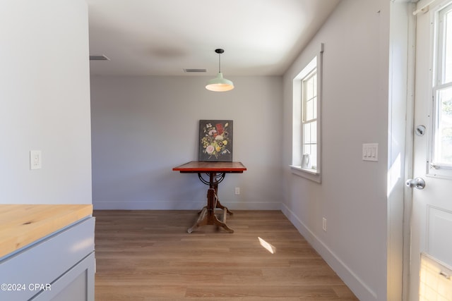 dining room with light wood-style flooring, visible vents, and baseboards