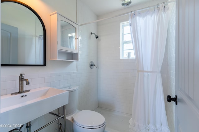 full bath with a stall shower, a sink, tile walls, and toilet