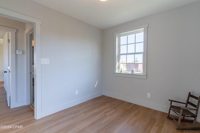 unfurnished room featuring baseboards and light wood finished floors