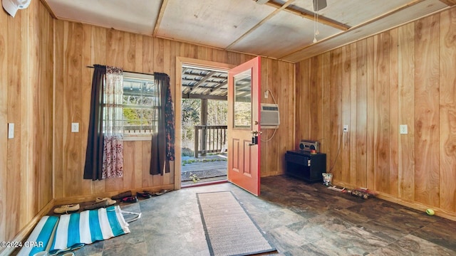 entryway featuring ceiling fan and wooden walls