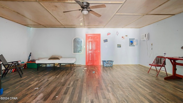 game room featuring a wall unit AC, ceiling fan, and dark wood-type flooring