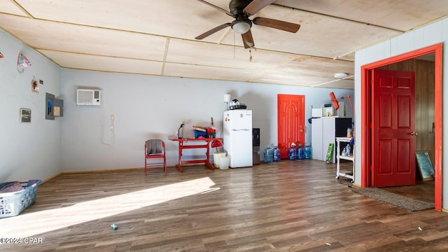 interior space featuring a wall mounted air conditioner, hardwood / wood-style floors, and ceiling fan