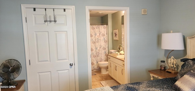 bedroom featuring connected bathroom and light tile patterned flooring