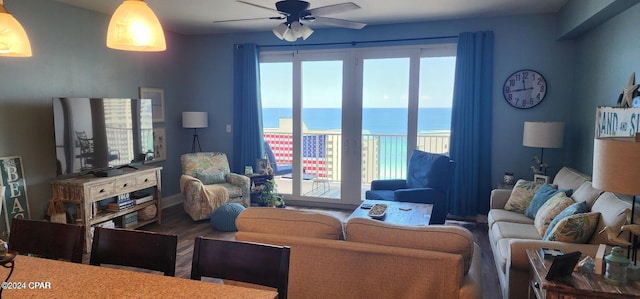 living room featuring ceiling fan, a water view, and wood-type flooring